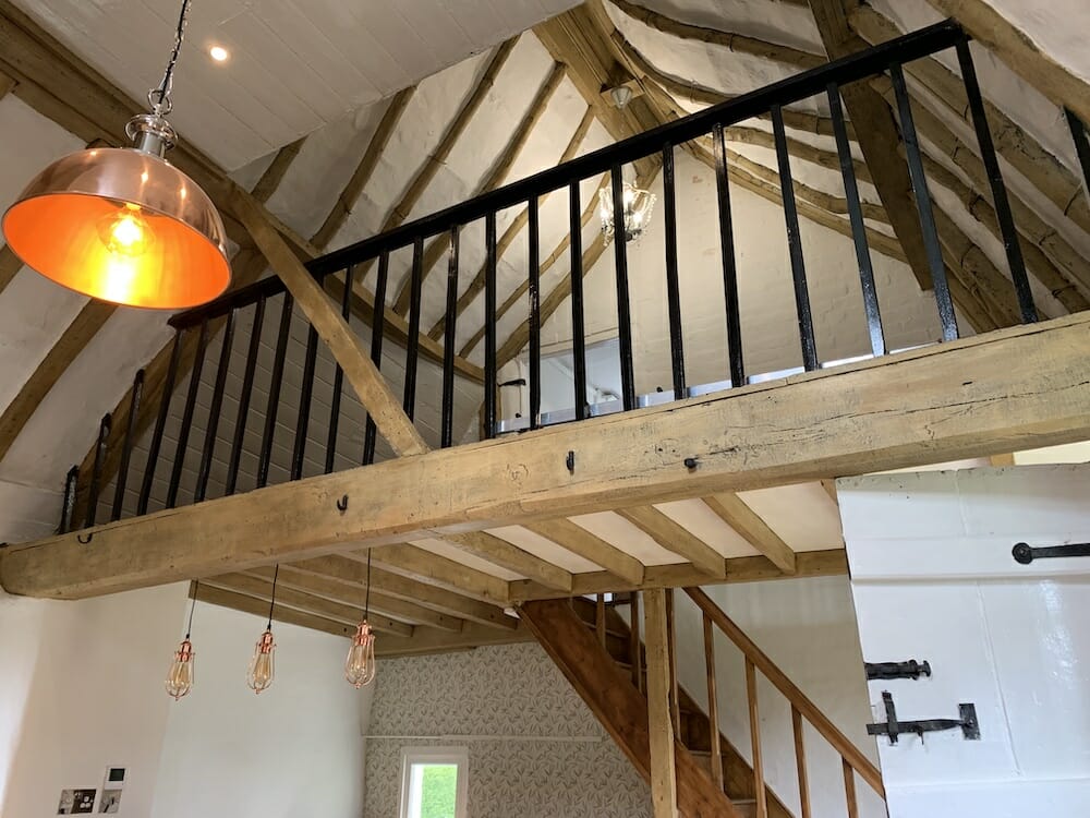 An image showing oak beam ceiling and bannisters after restoration